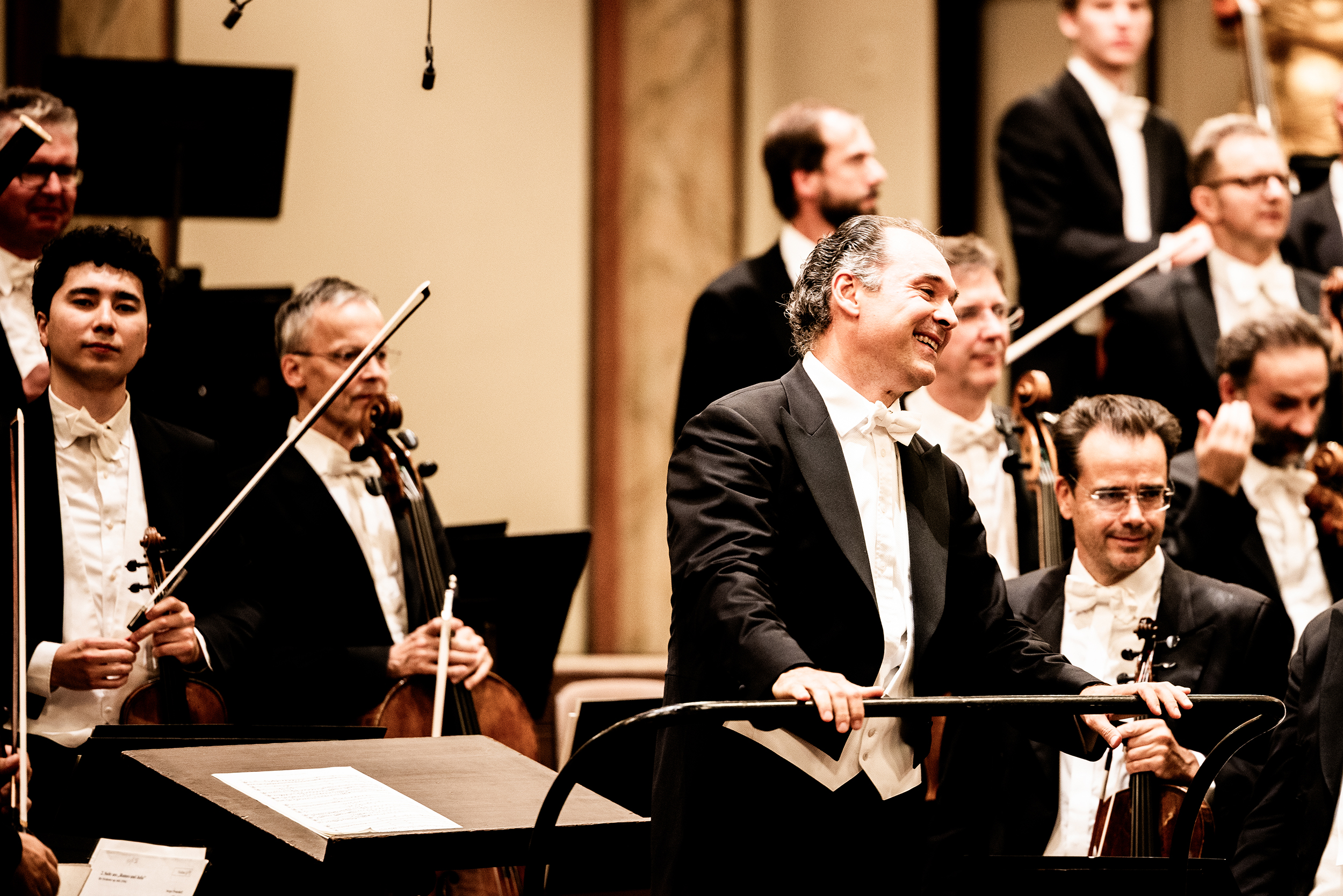 Tugan Sokhiev bei der Verbeugung nach dem Konzert. Im Hintergrund Orchestermitglieder